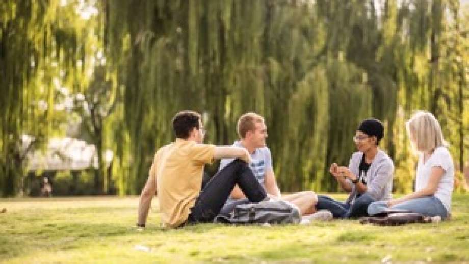 Group of students sitting on the lawns at ANU having a chat