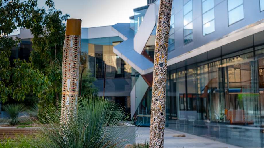 Image: Memorial and burial poles from Galiwin’ku installed at the John Curtin School of Medical Research. Photo by Jamie Kidston/ANU.