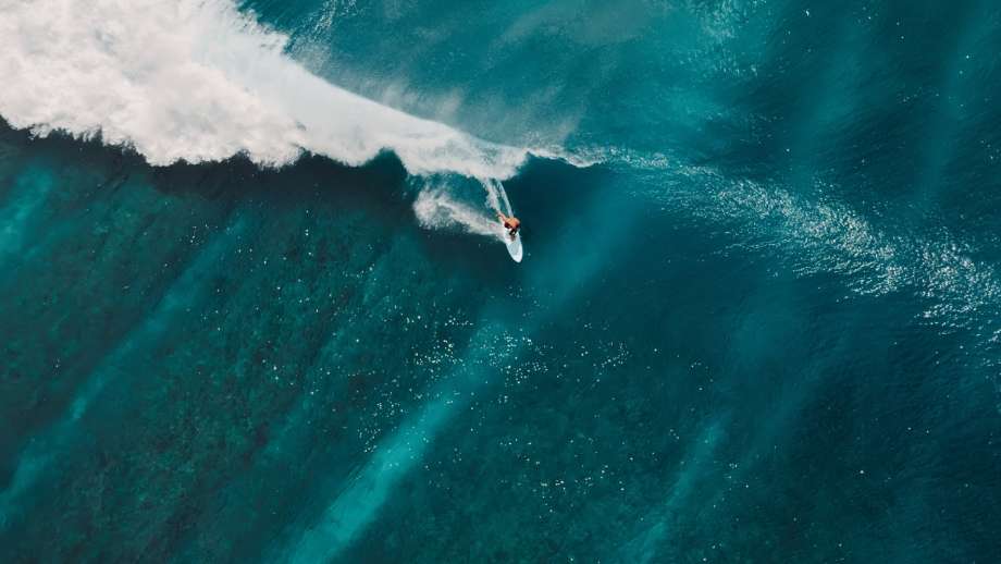 An aerial view of a surfer riding a wave