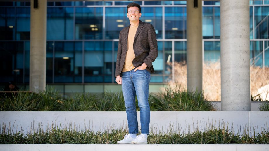 Full length shot of Sergey. he's facing the camera with one hand in his jeans pocket. 
