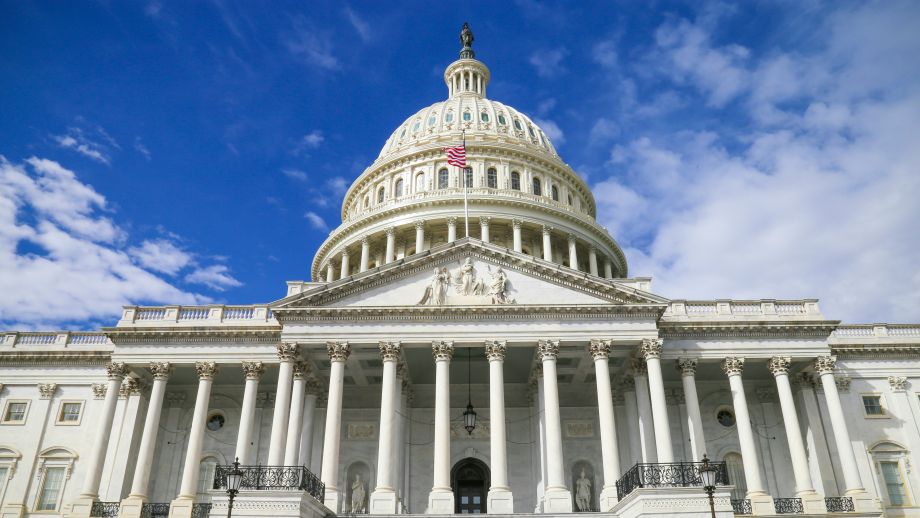 Pictured: front view of the United States Capitol Building with blue sky and clouds