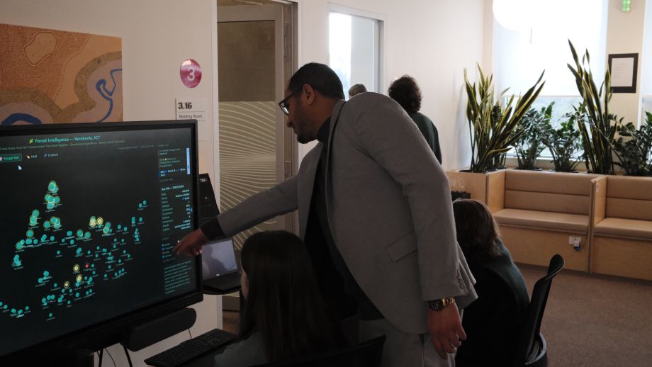 People looking at a computer screen pointing