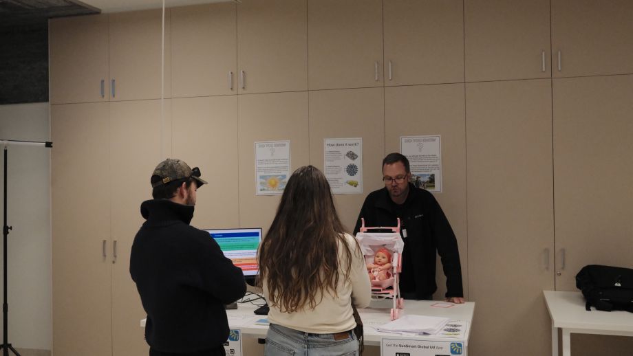 Three people standing around a desk