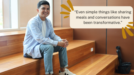 Alikhlas Lahaya sitting on brown stairs at College of Law smiling at the camera