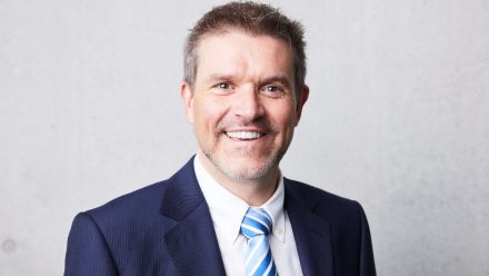 A man smiles towards the camera. 
