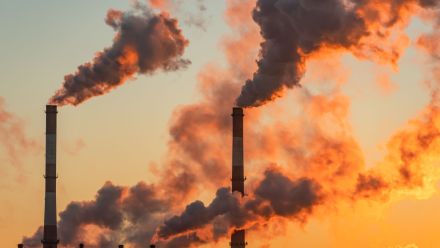 Aerial view of high smoke stack with smoke emission.