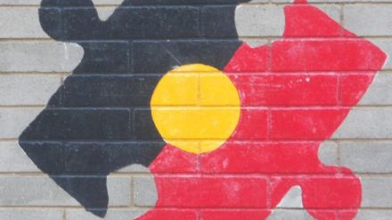 Mural of Australia's outline painted in Aboriginal flag colours.