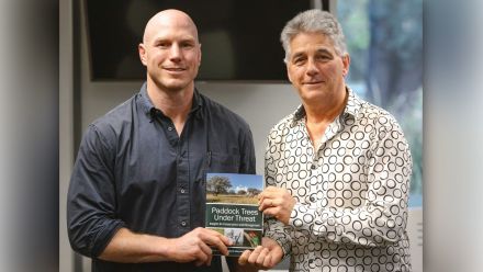 Senator David Pocock and Distinguished Professor David Lindenmayer holding a copy of Paddock Trees Under Threat.