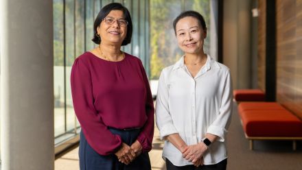 Two scientists pose for a photo indoors