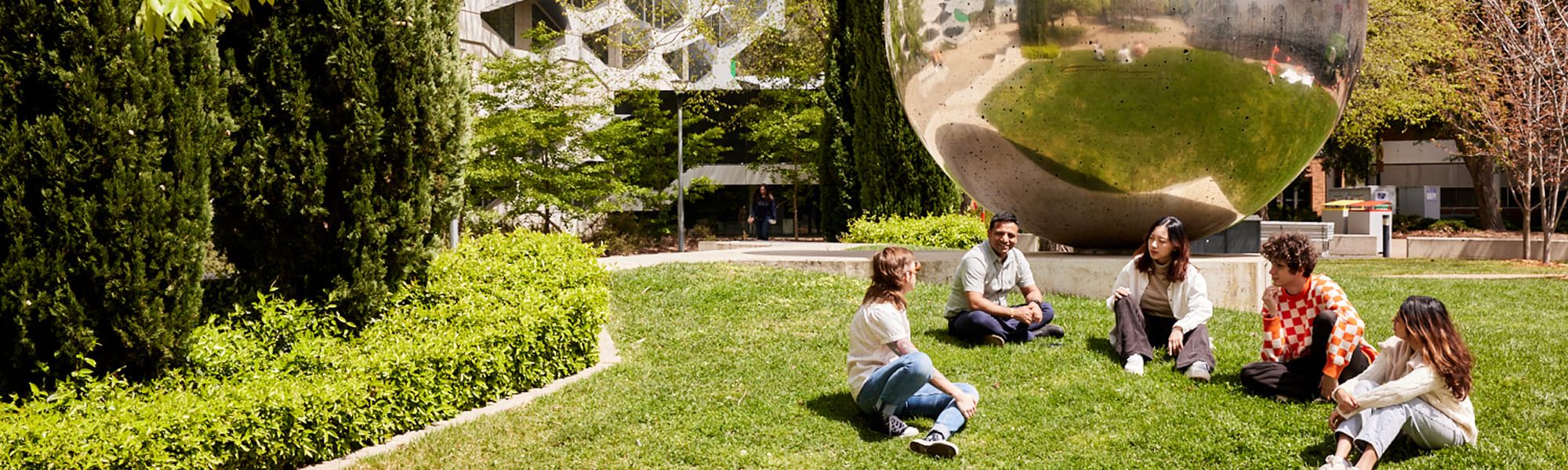 Five students sit in front of the UNA