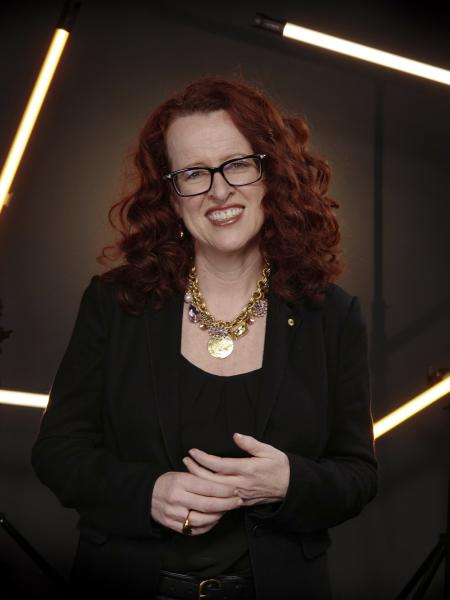 Genevieve Bell looking at camera and smiling, hands clasped together