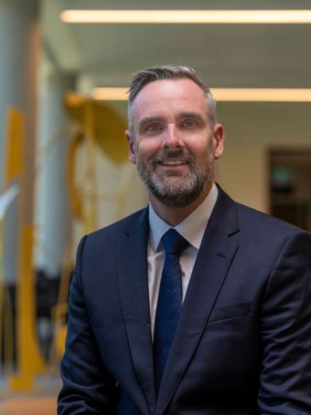 Michael Lonergan in a suit smiling at camera