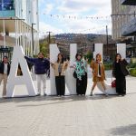 Group of friends in front of ANU sign