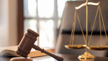 judge gavel, law books and scales of justice on desk in lawyer office.