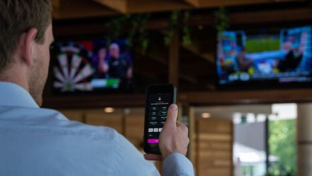 Man watching sport with phone betting