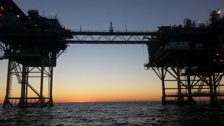 An offshore liquified natural gas production site at sunset